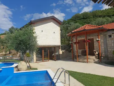 a house with a swimming pool next to a building at Rustic Villas Barlovic in Ulcinj
