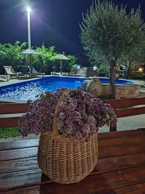 a basket of purple flowers sitting on a wooden bench at Rustic Villas Barlovic in Ulcinj