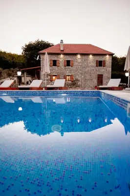 a large swimming pool in front of a house at Etno Villa Mokanji in Danilovgrad