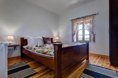 a bedroom with a wooden bed and a window at Etno Villa Mokanji in Danilovgrad