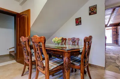 a dining room with a wooden table and chairs at Etno Villa Mokanji in Danilovgrad