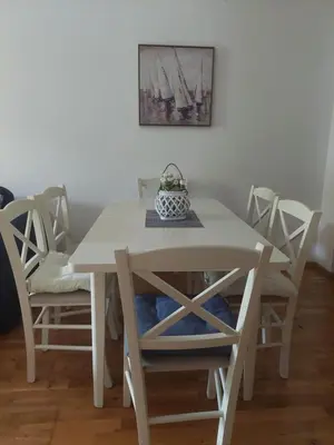 a white dining room table with chairs and a painting at Beauty apartment in Blue star complex Pržno Montenegro in Pržno