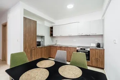 a kitchen with a black table and green chairs at Status-M Apartments 187 in Becici