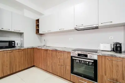 a kitchen with wooden cabinets and a stove top oven at Status-M Apartments 187 in Becici