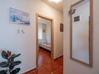 a hallway with a mirror and a room with a bed at Casa al mare Petrovac, Montenegro in Petrovac na Moru