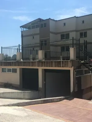 a building with two garage doors in front of it at Casa al mare Petrovac, Montenegro in Petrovac na Moru