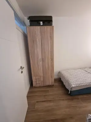 a bedroom with a bed and a small cabinet in the corner at Apart sunset in Bar