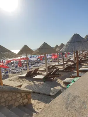 a group of chairs and umbrellas on a beach at Apart sunset in Bar