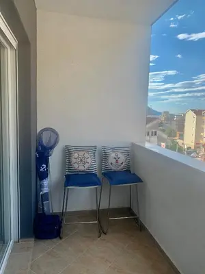 a balcony with two blue chairs and a window at BUDVA LUX in Budva