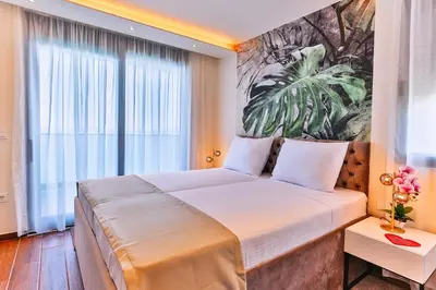 a bedroom with a large bed with a large window at APARTMENTS MERLIN in Dobra Voda
