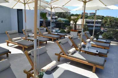 a row of chairs and umbrellas on a roof at APARTMENTS MERLIN in Dobra Voda
