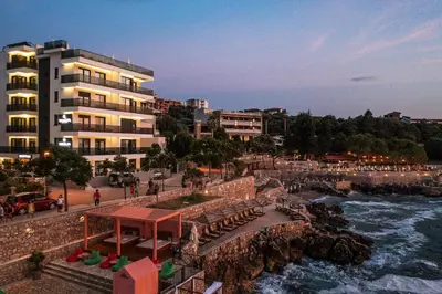a building next to a body of water at APARTMENTS MERLIN in Dobra Voda