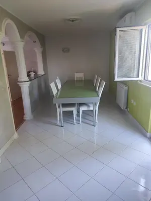 a dining room with a green table and chairs at VILA LUKA in Podgorica