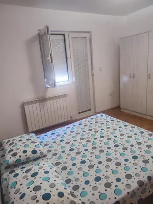 a bedroom with a bed with a blue and white comforter at VILA LUKA in Podgorica
