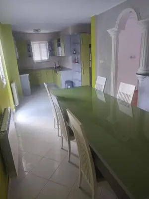 a dining room with a green table and chairs at VILA LUKA in Podgorica