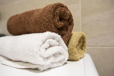 a pile of towels sitting on top of a toilet at Mina Studio Apartment Budva in Budva