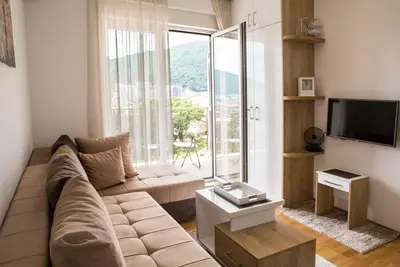 a living room with a couch and a large window at Mina Studio Apartment Budva in Budva