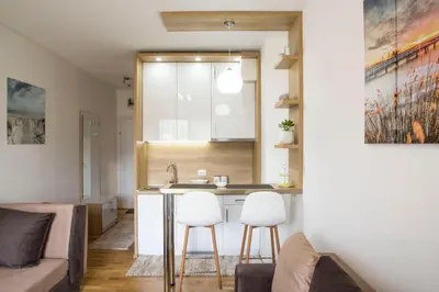 a kitchen and living room with a sink and two stools at Mina Studio Apartment Budva in Budva