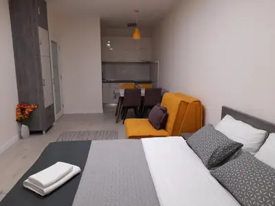 a bedroom with a bed and a table and chairs at Apartment Diamond in Podgorica