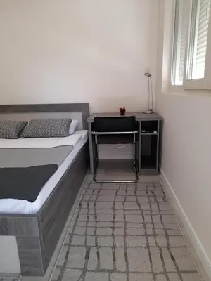 a bedroom with a bed and a side table at Apartment Diamond in Podgorica