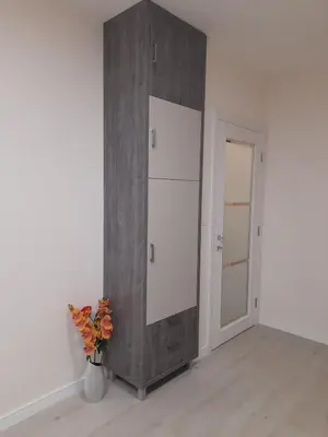 a room with a white refrigerator and a vase with flowers at Apartment Diamond in Podgorica