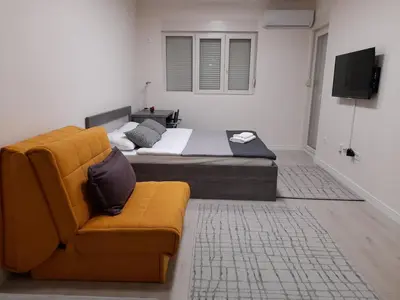 a bedroom with a bed and a couch and a television at Apartment Diamond in Podgorica