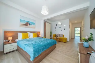 a bedroom with a large bed with a blue blanket at Passerella Apartments in Bar