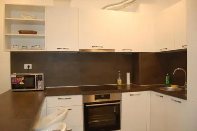 a kitchen with white cabinets and a stove top oven at Status-M Apartments 152 in Becici