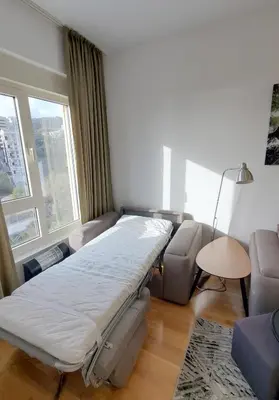 a hospital bed in a room with a couch and a window at Status-M Apartments 152 in Becici