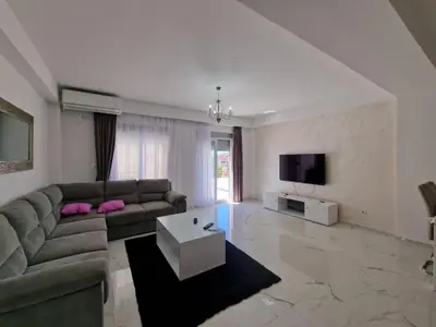 a living room with a couch and a tv at ATA APARTMANI. in Petrovac na Moru