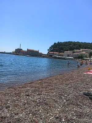 a group of people on a beach near the water at ATA APARTMANI. in Petrovac na Moru