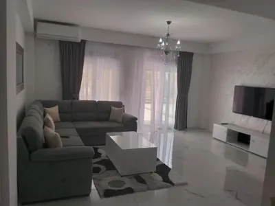 a living room with a couch and a tv at ATA APARTMANI. in Petrovac na Moru