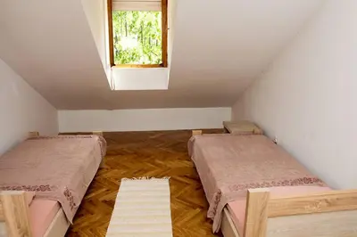 a attic room with two beds and a window at Green House in Cetinje