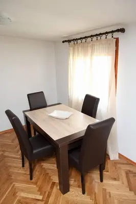a dining room table with black chairs and a window at Green House in Cetinje