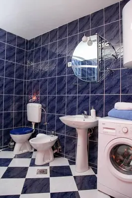 a bathroom with two toilets and a sink and a washing machine at Green House in Cetinje