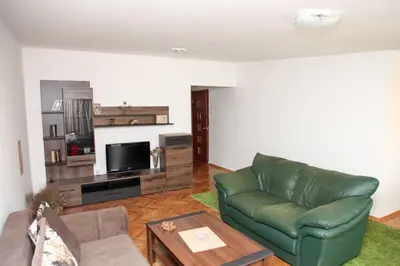 a living room with a green couch and a television at Green House in Cetinje