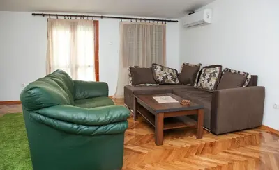 a living room with a couch and a table at Green House in Cetinje