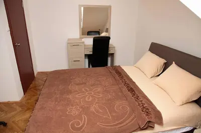 a bedroom with a bed with a desk and a mirror at Green House in Cetinje