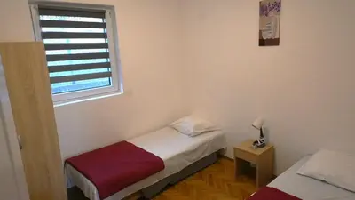 a small bedroom with two beds and a window at VIVANA HOUSE in Bar, Susanj