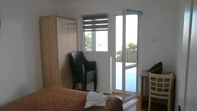a bedroom with a bed and a chair and a window at VIVANA HOUSE in Bar, Susanj