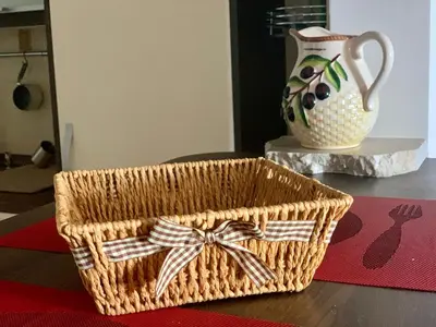 a basket with a bow on a table with a vase at Apartment Ruzmarin Petrovac in Petrovac na Moru