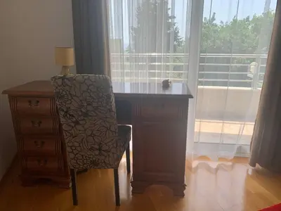 a desk with a chair next to a window at Apartment Ruzmarin Petrovac in Petrovac na Moru