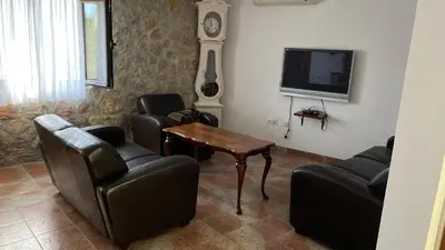 a living room with chairs and a table and a tv at House in the Mountains near Budva in Budva
