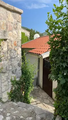 a garage with a brown door and a red roof at House in the Mountains near Budva in Budva