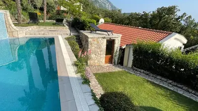 a swimming pool with a bench next to a house at House in the Mountains near Budva in Budva