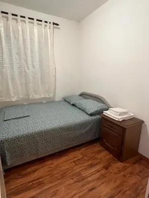 a bedroom with a bed and a dresser and a window at Apartman Savo in Kotor