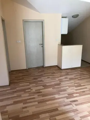 an empty room with a wooden floor and a door at Apartman Savo in Kotor