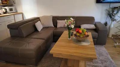 a brown couch with a table and a bowl of fruit at Apartman Livada Bar in Bar
