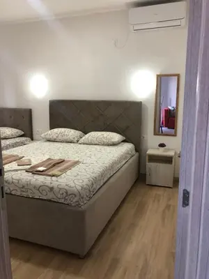 a bedroom with a large bed and a mirror at Margaritaville in Ulcinj