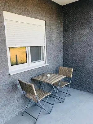 a table and chairs in a room with a window at Margaritaville in Ulcinj